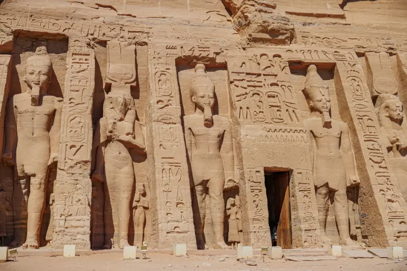 Facade of the Small Temple at Abu Simbel in Egypt with colossal statues of Pharaoh Ramesses II and Queen Nefertari carved into rock — UNESCO World Heritage site.